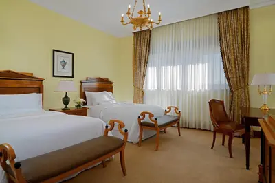 a hotel room with two beds and a desk at The Westin Excelsior, Rome in Rome