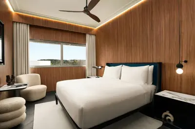 a bedroom with a large white bed and a chair at Cardo Roma, Autograph Collection in Rome