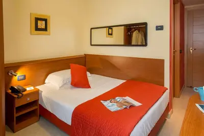 a bedroom with a bed with a red blanket and a mirror at Best Western Blu Hotel Roma in Rome