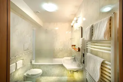 a white bathroom with a toilet and a sink at Best Western Blu Hotel Roma in Rome