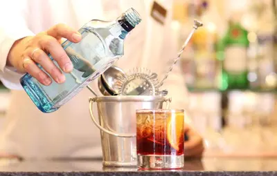 a bartender pouring a drink into at Bettoja Hotel Massimo d'Azeglio in Rome