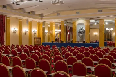 a room with red chairs and a statue of a man at Bettoja Hotel Massimo d'Azeglio in Rome