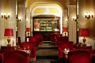a restaurant with red chairs and a bar at Bettoja Hotel Massimo d'Azeglio in Rome