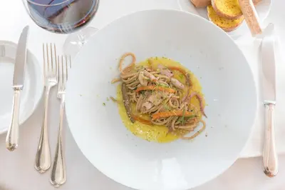 a white plate of food on a table at Bettoja Hotel Atlantico in Rome