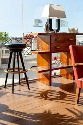 a table and a stool with wine glasses on it at Bettoja Hotel Atlantico in Rome