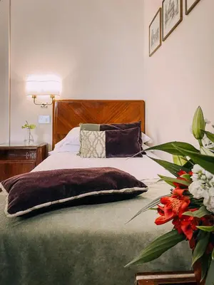 a bedroom with a bed with a pillow and flowers at Bettoja Hotel Atlantico in Rome