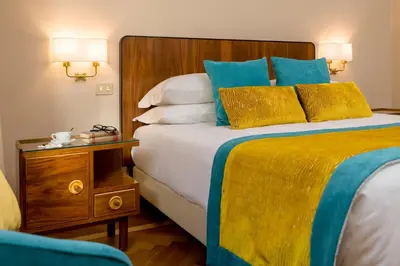 a bedroom with a large bed with blue and yellow sheets at Bettoja Hotel Mediterraneo in Rome