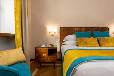 a hotel room with two beds and a chair at Bettoja Hotel Mediterraneo in Rome