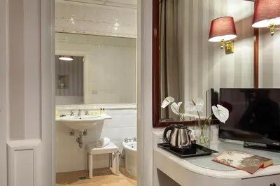 a bathroom with a sink and a toilet and a television at Hotel Nord Nuova Roma in Rome