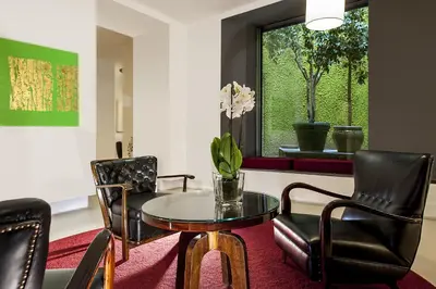 a living room with a table and chairs and a window at Hotel Nord Nuova Roma in Rome