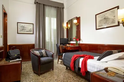 a hotel room with a bed and a desk at Hotel Nord Nuova Roma in Rome