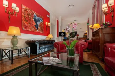 a living room with red walls and red furniture at Hotel Nord Nuova Roma in Rome