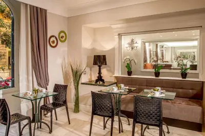 a dining room with a table and chairs and a mirror at Ludovisi Palace Hotel in Rome