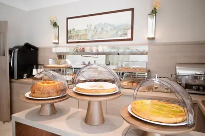 a bakery with three trays of breads and cakes at Ludovisi Palace Hotel in Rome