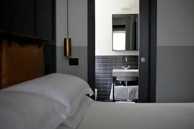 a bedroom with a white bed and a sink at c-hotels Club House Roma in Rome