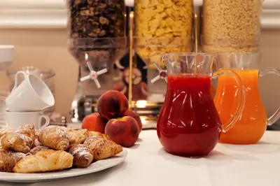 a table with a plate of food and a cup of tea at c-hotels Club House Roma in Rome