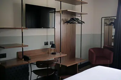 a room with a desk with a tv and a chair at c-hotels Club House Roma in Rome