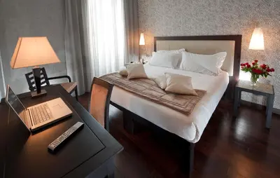 a bedroom with a bed and a desk with a laptop at c-hotels Fiume in Rome