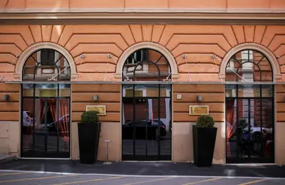 a building with three windows and three potted plants at c-hotels Fiume in Rome