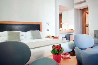 a bedroom with a large bed and blue chairs at Best Western Ars Hotel in Rome