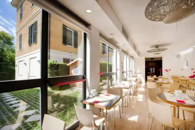 a restaurant with tables and chairs and large windows at Best Western Ars Hotel in Rome