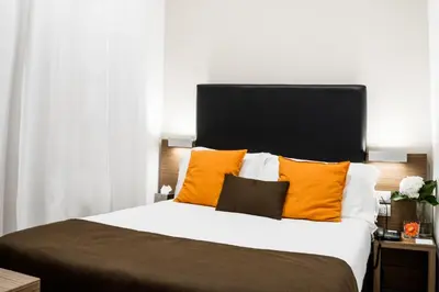 a bedroom with a large bed with orange pillows at Hotel Concordia in Rome