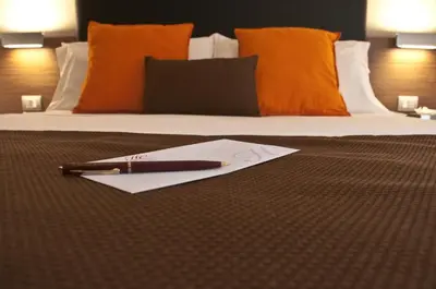 a pen and piece of paper on a bed at Hotel Concordia in Rome