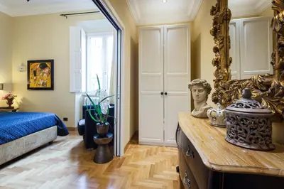 a bedroom with a bed and a mirror and a table at Casa Roma Luxury Apartment in Rome