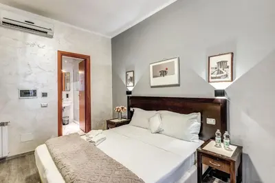 a bedroom with a white bed and a bathroom at Hotel Family House in Rome