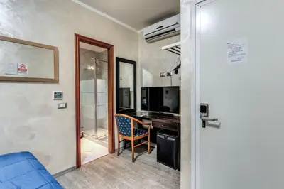 a room with a desk with a computer and a chair at Hotel Family House in Rome