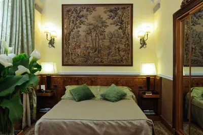 a bedroom with a bed with a tapestry on the wall at Hotel Farnese in Rome