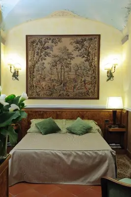 a bedroom with a large tapestry above a bed at Hotel Farnese in Rome