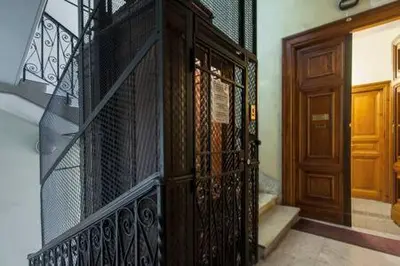 a staircase with a iron gate and a wooden door at Marta Guest House in Rome