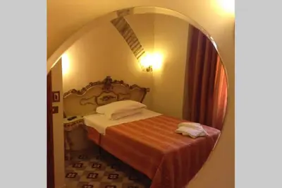 a bedroom with a bed and a mirror at Marta Guest House in Rome