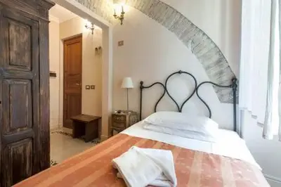 a bedroom with a large bed with white pillows at Marta Guest House in Rome