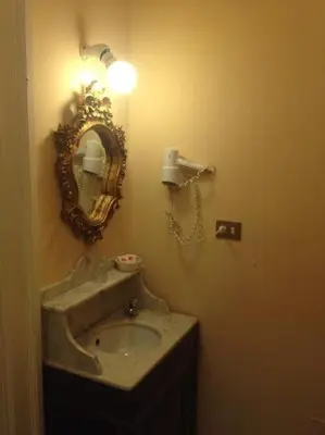 a bathroom with a sink and a mirror on the wall at Marta Guest House in Rome