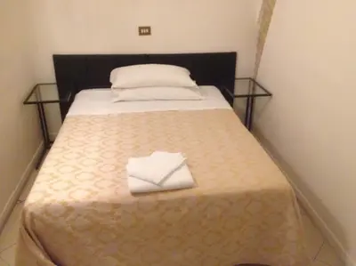 a bedroom with a bed with a white towel on it at Marta Guest House in Rome