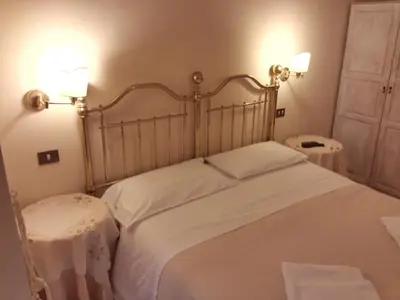 a bedroom with a large white bed with two tables at Marta Guest House in Rome