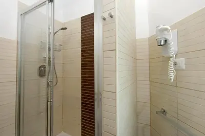 a shower with a phone in a bathroom at 4BNB - Otranto Vatican Apartment in Rome