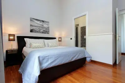 a white bedroom with a large bed with white sheets at 4BNB - Otranto Vatican Apartment in Rome