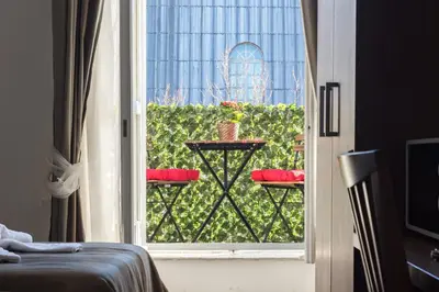 a room with a window with a table with red pillows at Sweet Holidays In Rome in Rome