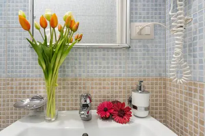 a vase of flowers sitting on top of a sink at Sweet Holidays In Rome in Rome