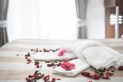 a bed with white towels and flowers on the floor at Sweet Holidays In Rome in Rome