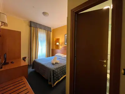 a hotel room with a bed and a door open at Baltik Guesthouse in Rome