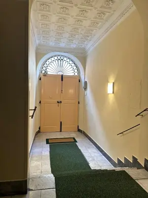 a hallway with a door and a green rug at Baltik Guesthouse in Rome