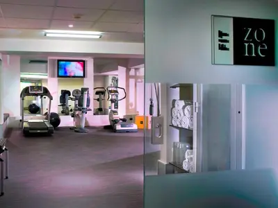 a gym with treadmills and machines in a room at Hotel Zone in Rome