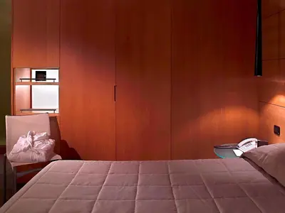 a bedroom with a bed and a wooden cabinet at Hotel Zone in Rome