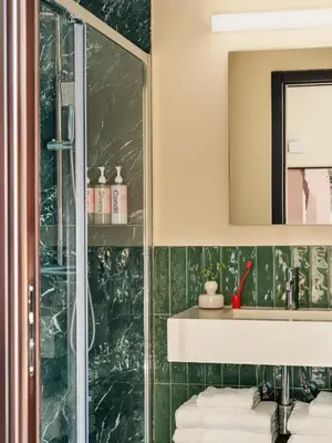 a bathroom with a glass shower and a sink at Numa Rome Barberini in Rome