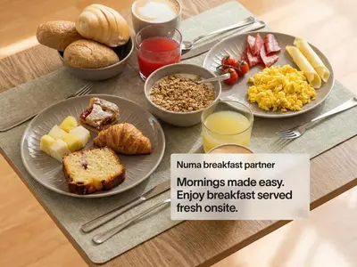 a table with plates of breakfast food on it at Numa Rome Barberini in Rome