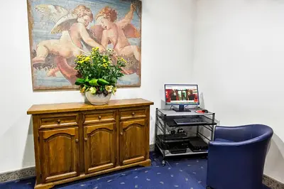 a waiting room with blue couches and paintings on the wall at Hotel Diplomatic in Rome